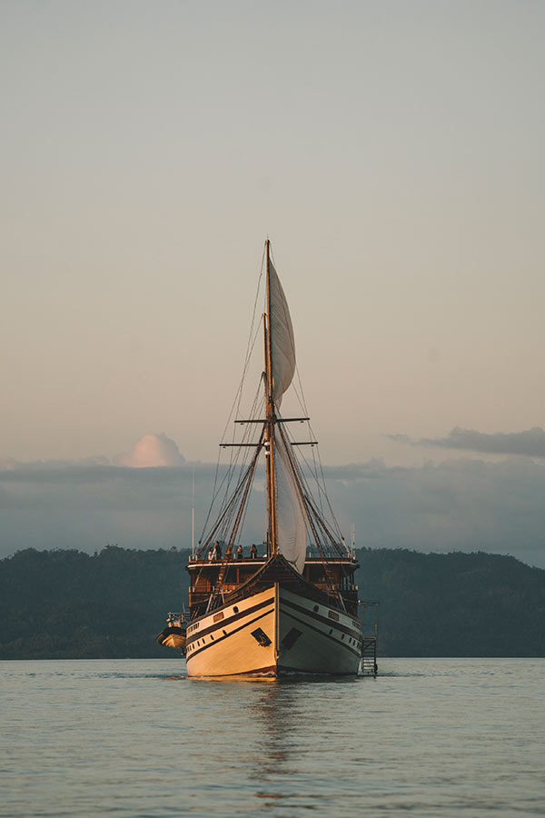 Traditional phinisi sailing at golden hour, Indonesia